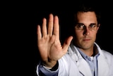 Man in white coat with hand raise in stop signal