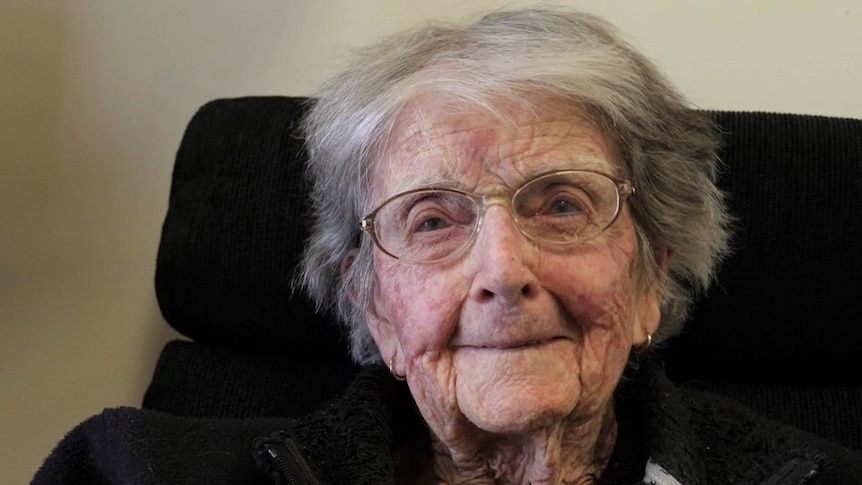 Elderly lady face closeup, wearing glasses smiling at camera