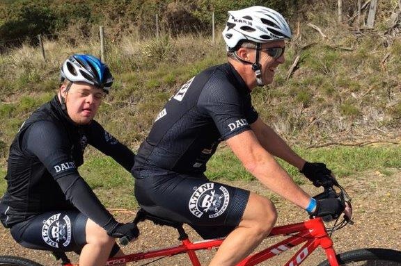 Steve rides a tandem bike with his disabled son Joel