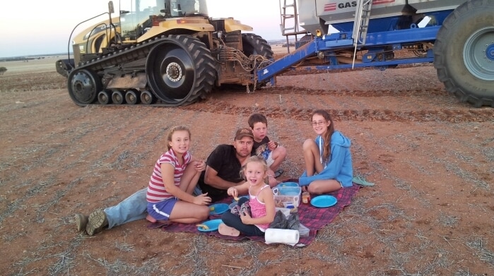 Family enjoying a picnic  lunch in the paddock