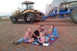 Family enjoying a picnic  lunch in the paddock