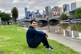 A man sitting on the grass next to the Yarra River