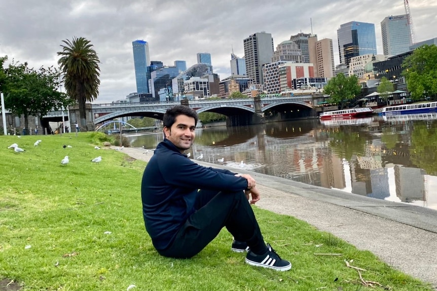 A man sitting on the grass next to the Yarra River