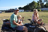 Rob Catania sits on a quad bike with his two children Jade and Henry.