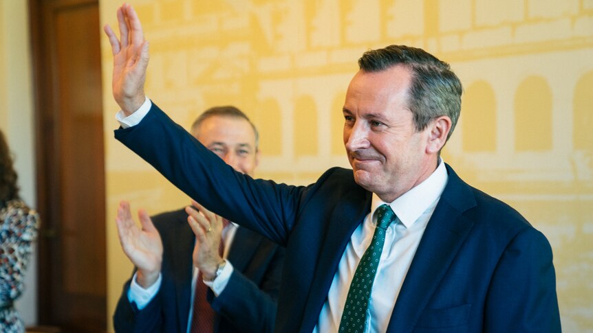 A mid shot of Mark McGowan acknowledging applause during a party meeting.