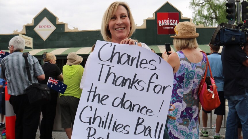 Adelaide woman Clare Morrow holds a sign thanking Prince Charles for a dance they once had
