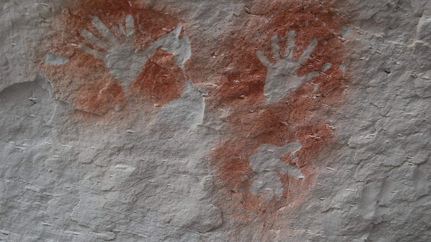 Indigenous rock art painting of hands and a kookaburra in a cave at Carnarvon Gorge
