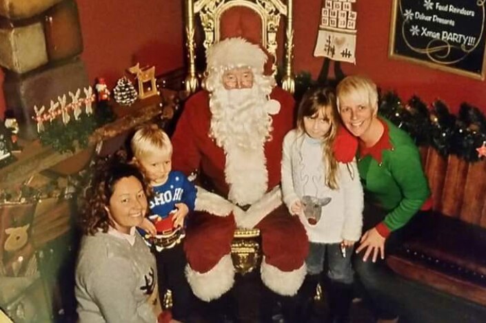 The Sargent family pose with a man dressed as Santa Claus.