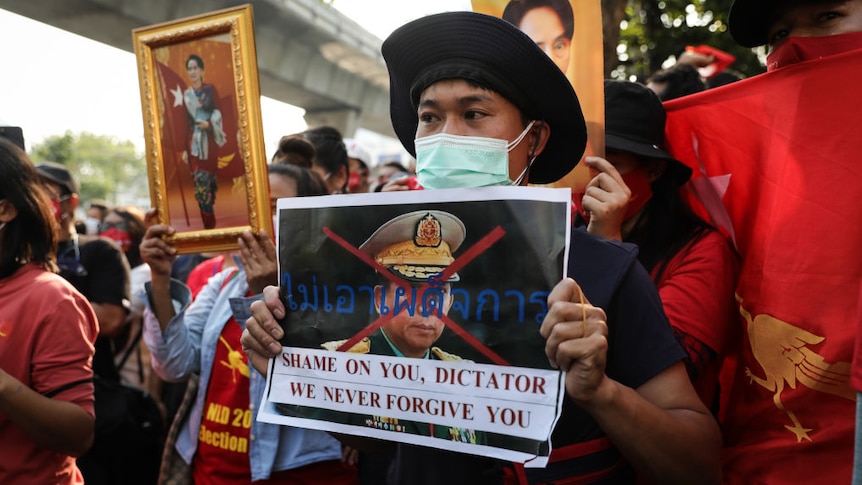 A protester holds up an image of Myanmar junta leader General Min Aung Hliang outside the Myanmar embassy in Bangkok.