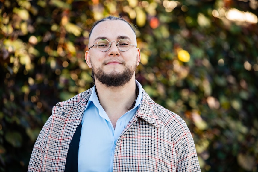 A man with a beard and glasses smiling at the camera.