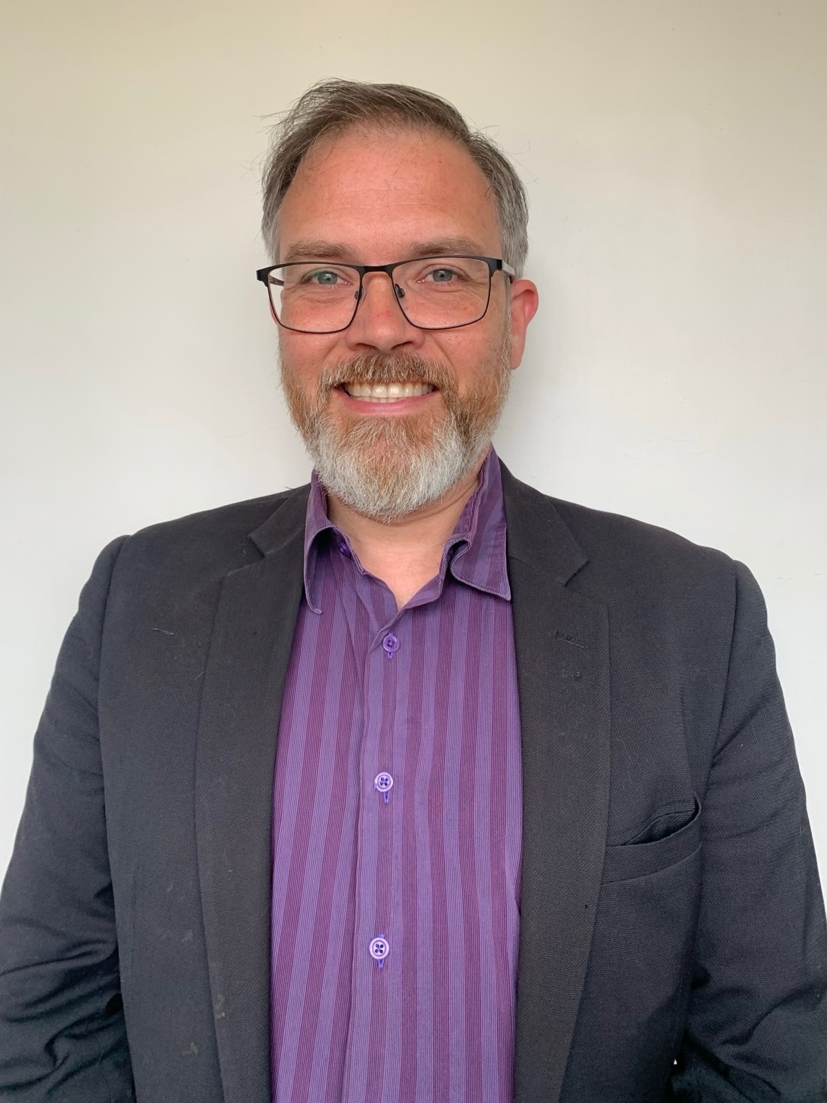 Man with a beard and glasses.