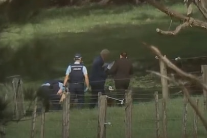 A group of police officers stand in a paddock.