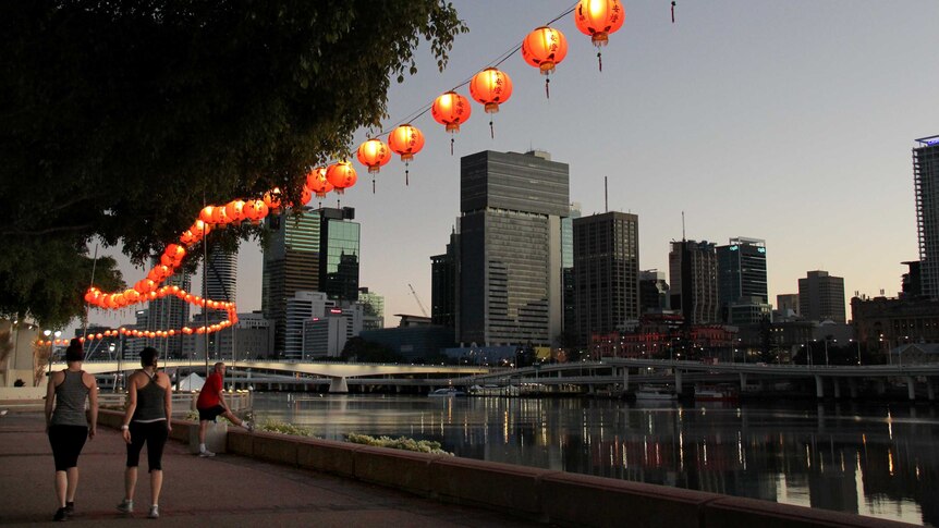 Early morning joggers run past red lanterns hanging at South Bank ahead of the Buddha Birth Day Festival.