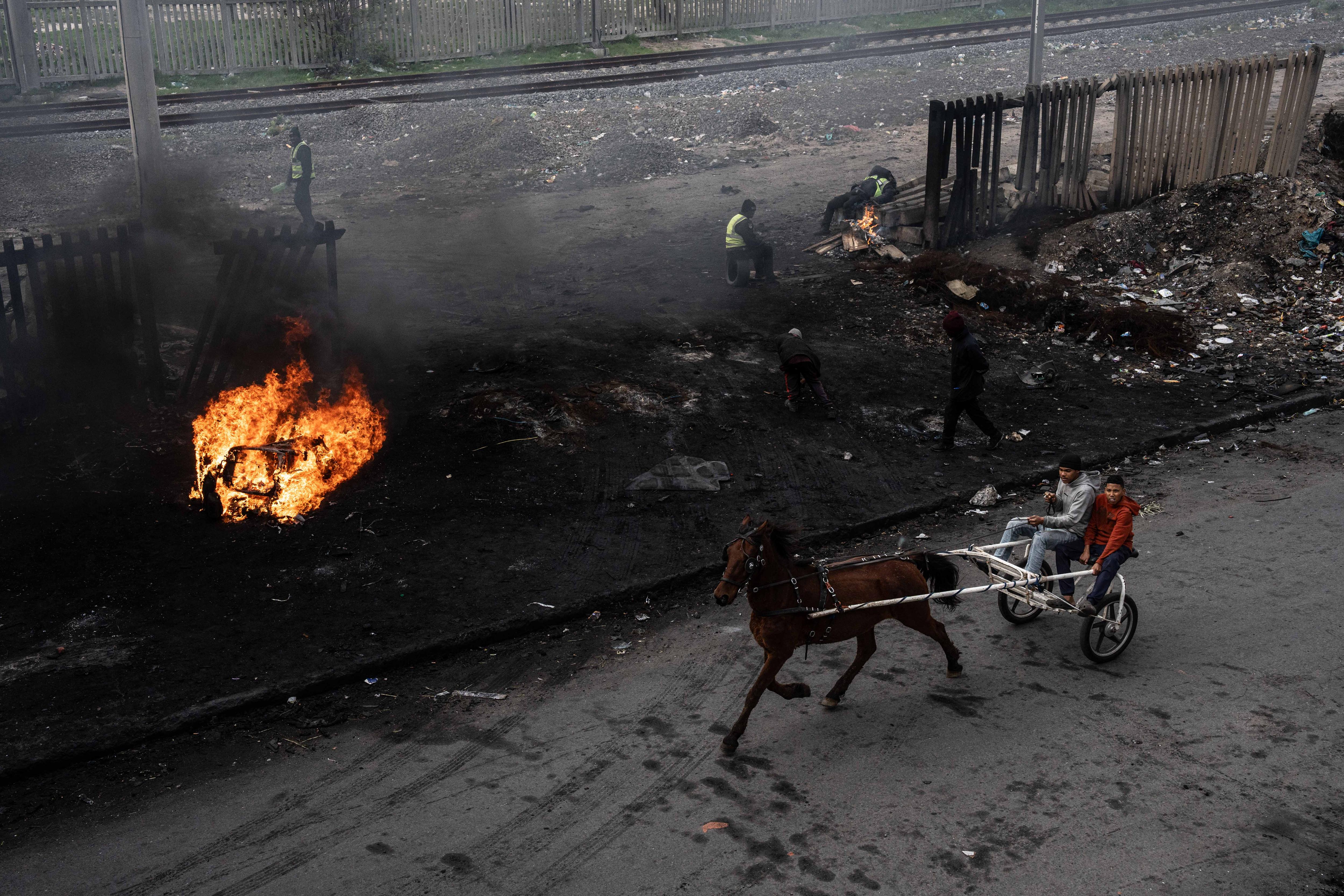 A horse buggy going past a fire.