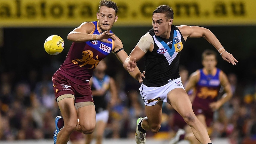 Brisbane's James Aish competes with Port Adelaide's Karl Amon at the Gabba on May 17, 2015.