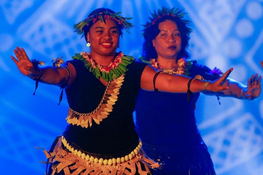 Women dance in traditional dress.