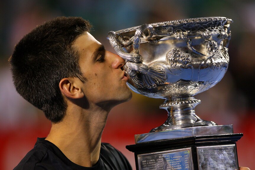 A young Novak Djokovic kisses the Australian Open trophy