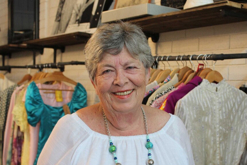 A lady stands in a clothing store.