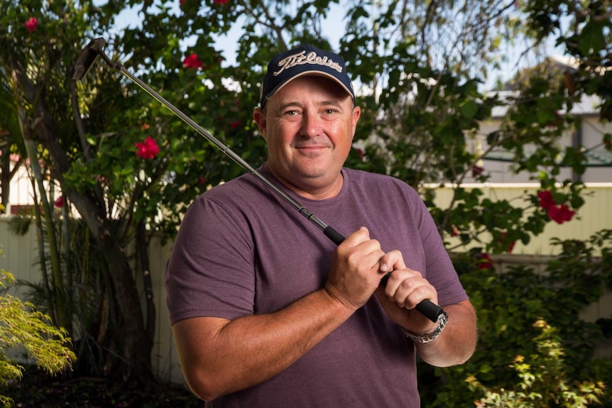 Matt Laroche holds a putter.