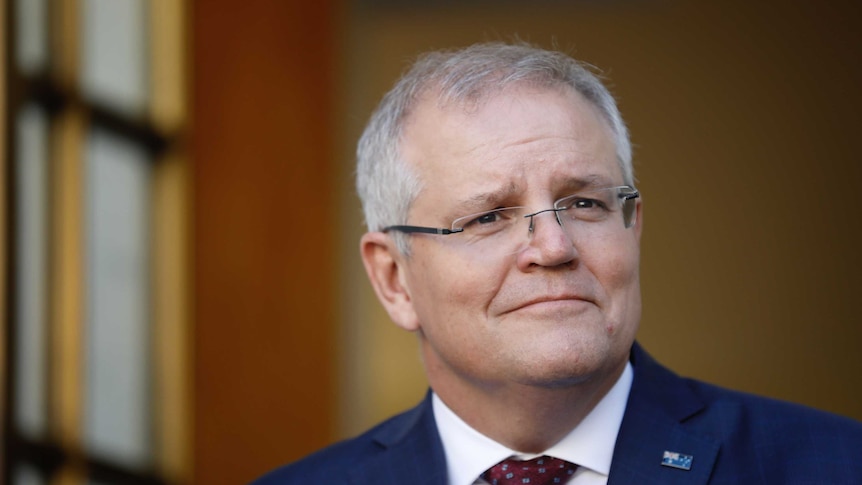 Scott Morrison looks to the distance as he stands in a courtyard