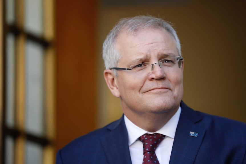 Scott Morrison looks to the distance as he stands in a courtyard