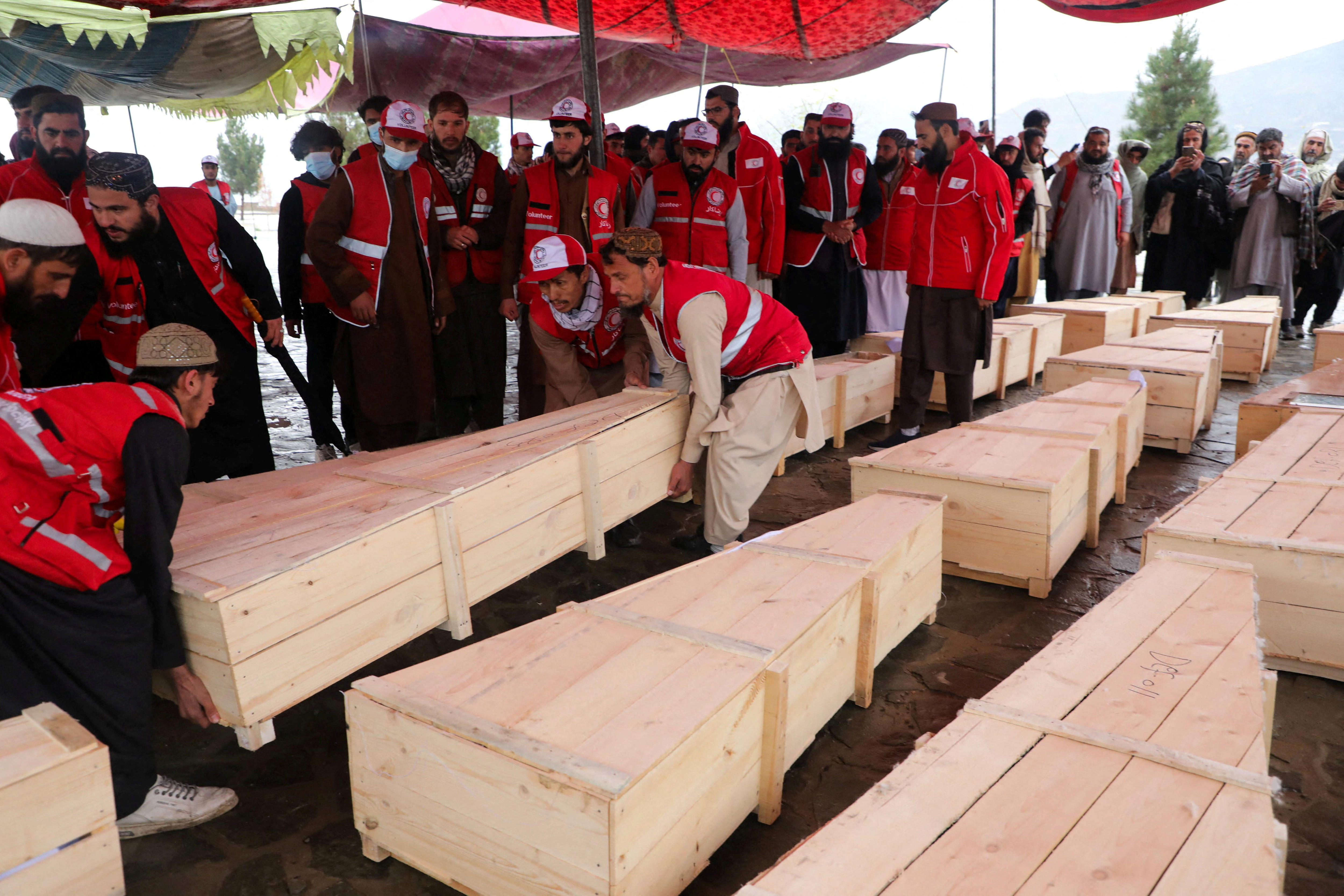 مردم در حین دفن دسته جمعی در کابل تابوت حمل می کنند.