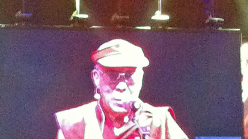 The Dalai Lama on a large video screen addressing a crowd at Perth's Burswood Dome venue