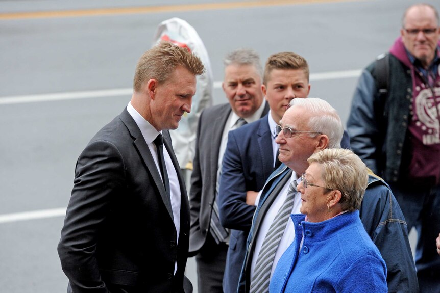Nathan Buckley speaks to family members outside church ahead of Lou Richard's funeral service.
