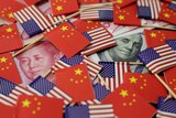 A illustration of US and Chinese flags covering currency
