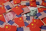 A illustration of US and Chinese flags covering currency