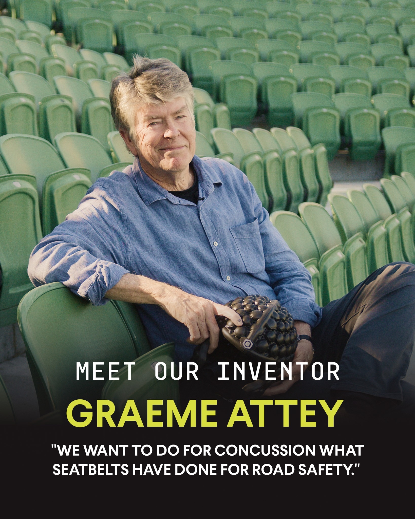 Um homem de meia idade está sentado em uma arquibancada, segurando um capacete esportivo preto.