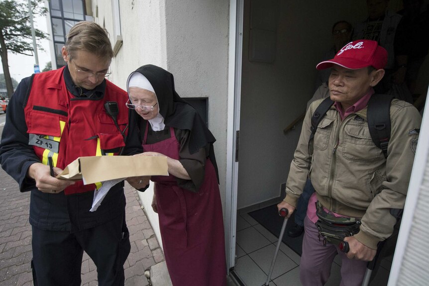 A member of the fire brigade coordinates with a sister of a homeless shelter during the evacuation.