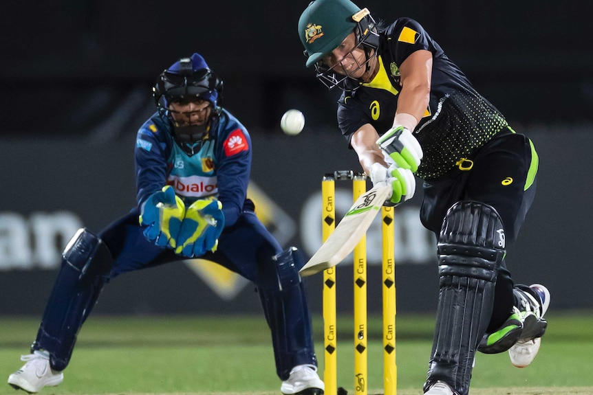 Alyssa Healy plays a lofted shot towards the off side. The wicketkeeper watches on intently.