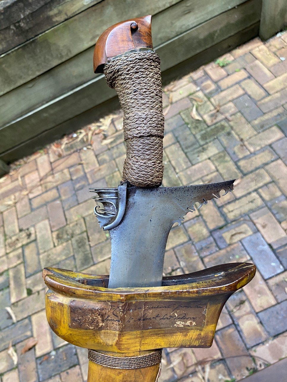 Detail of a sword's carvings and hemp-wrapped handle.