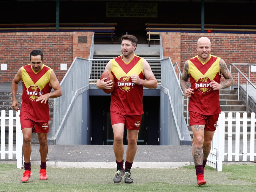 three afl players running on the field