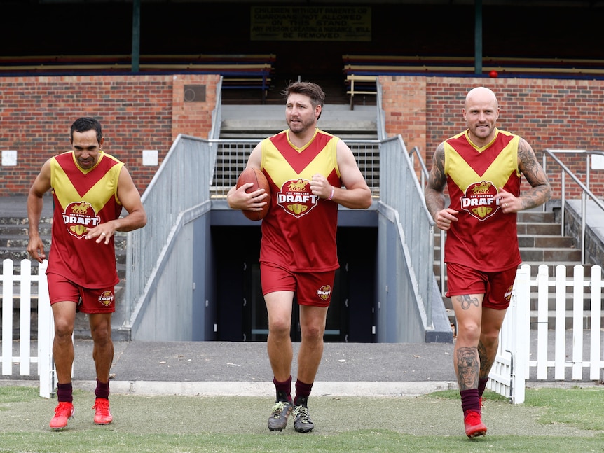 three afl players running on the field