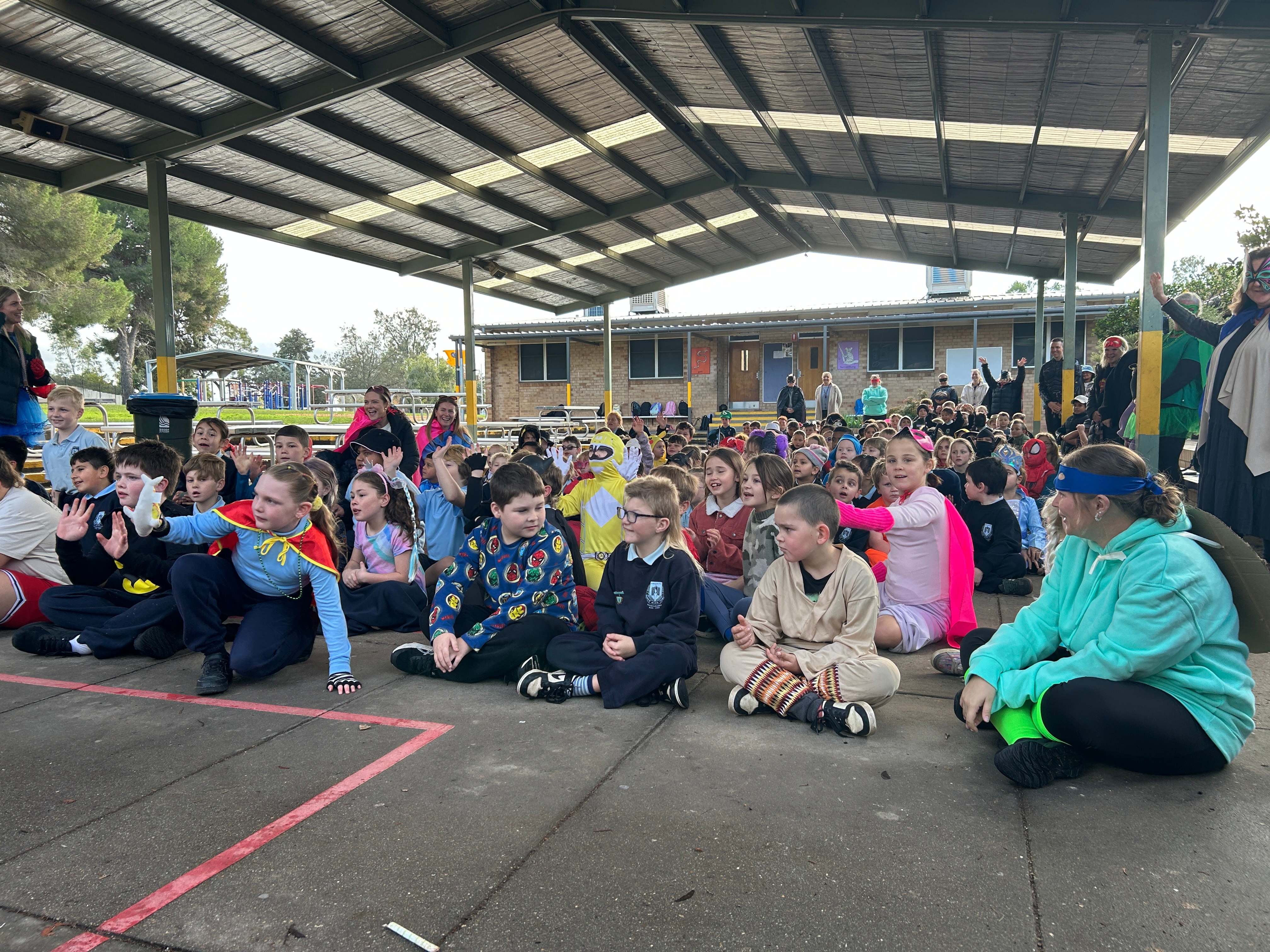 picture of school students sitting on the ground 