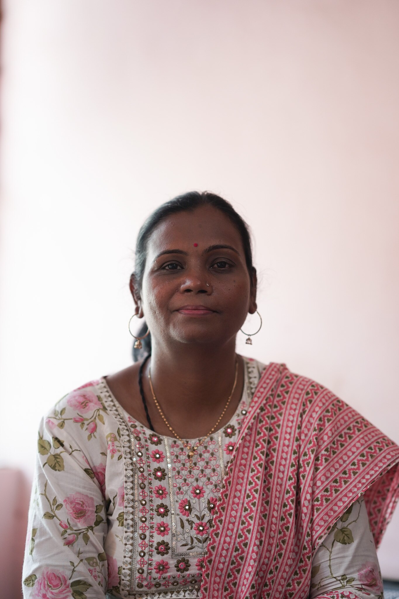 A close up of a woman smiling while wearing circle earings.