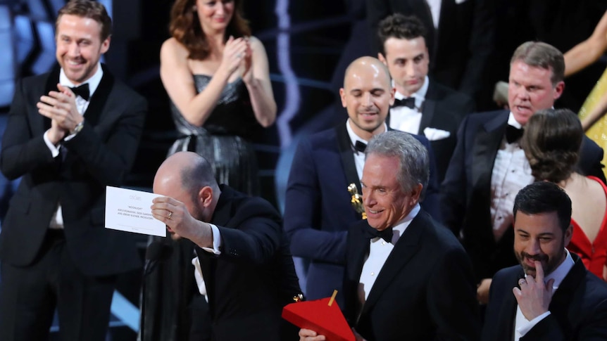 Jordon Horowitz holds up the card for Best Picture next to Warren Beatty and Jimmy Kimmel.