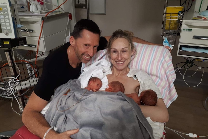 Triplets Liliana, Isabella and Charlotte Fitzgerald as newborns on mum Leonie's chest and dad Peter in hospital