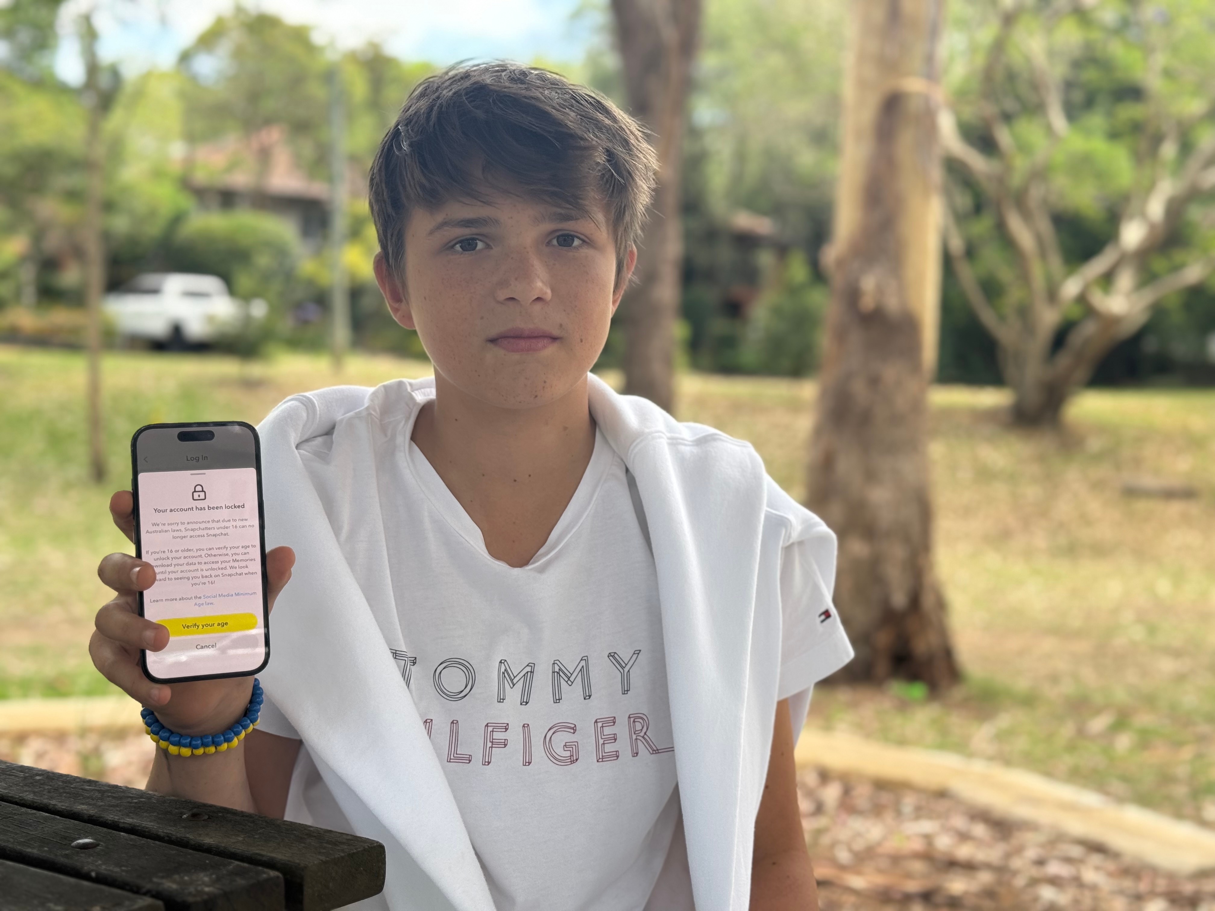 Ilia Kyrychenko é uma adolescente vestida de branco e segurando um telefone celular.