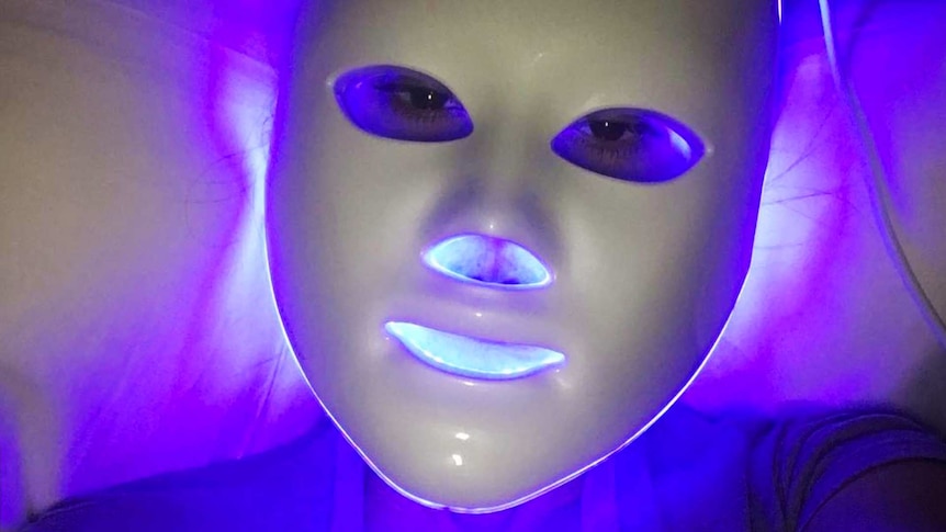 Celebrity Kourtney Kardashian using an LED mask for a story about what to know before trying at-home LED masks.