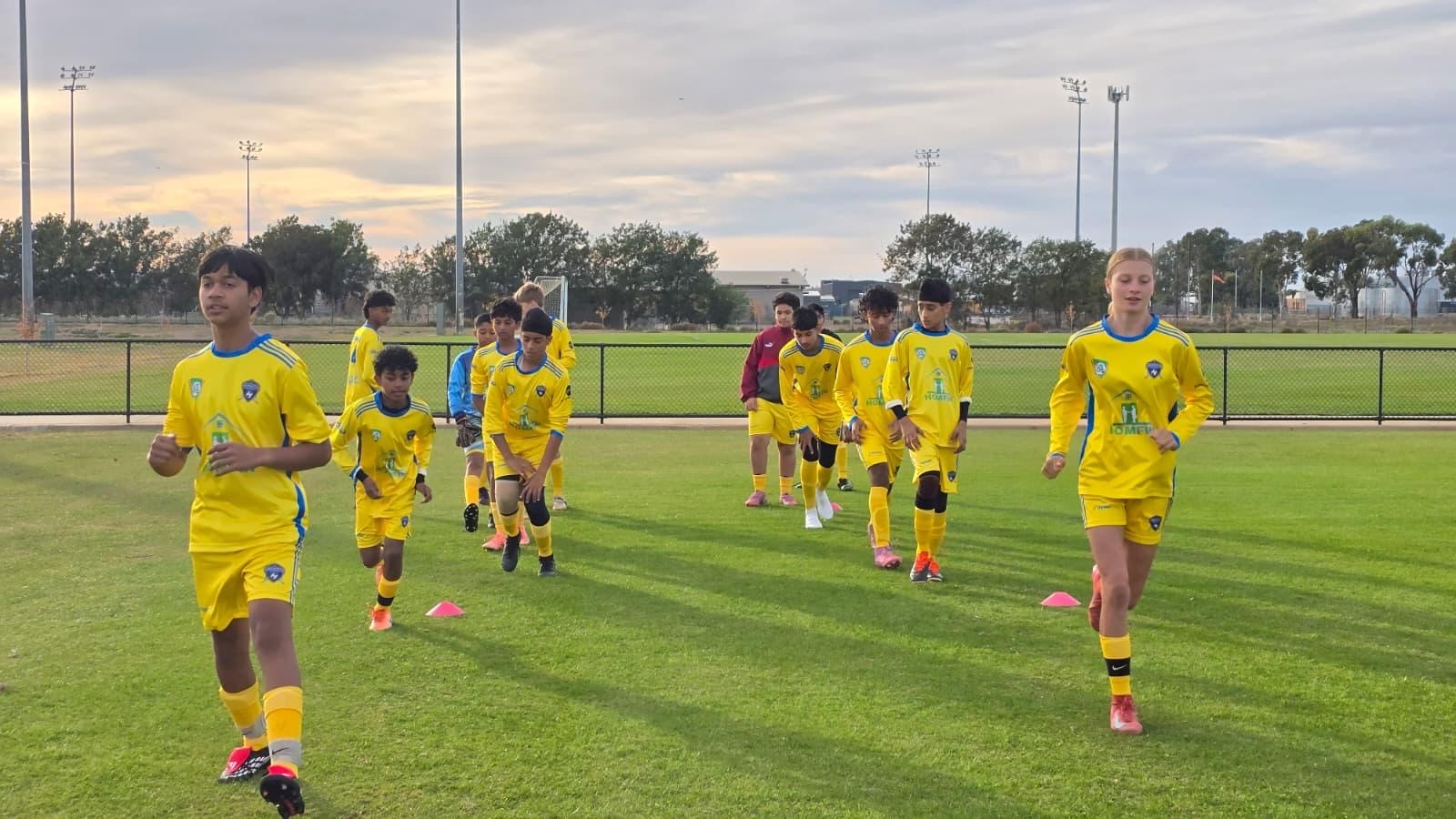 Twelve young soccer platers warming up on the grounds