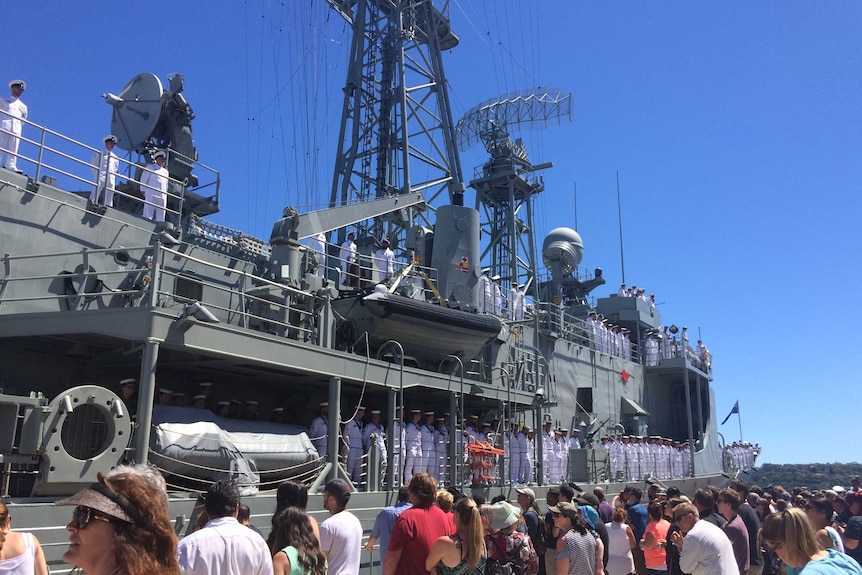 People gather around the departing vessel.