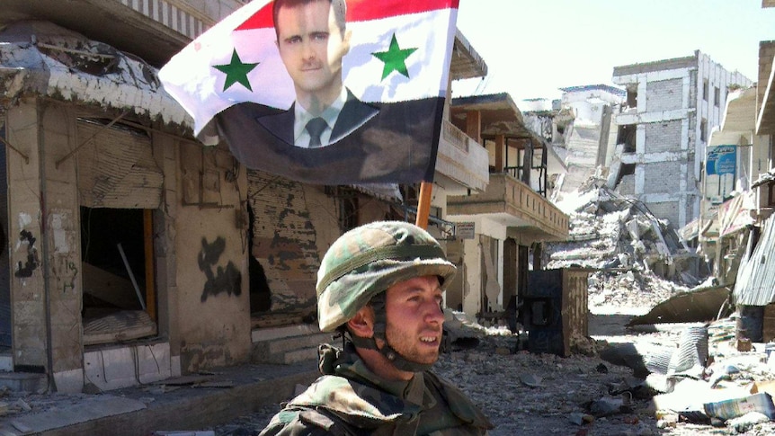 Syrian army soldier walks through Qusayr