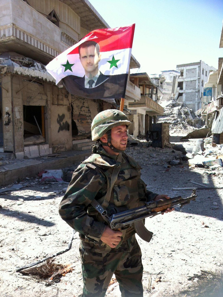 Syrian army soldier walks through Qusayr