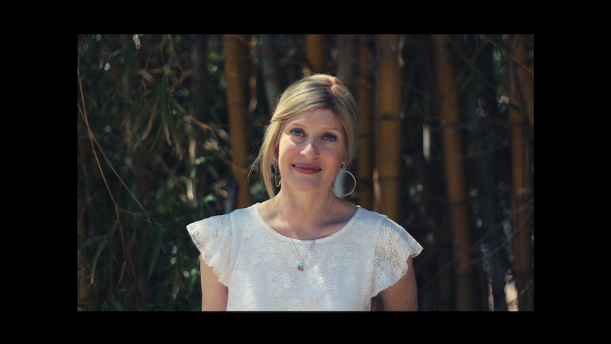 Louise Pryke with a gentle smile against a background of bamboo plants