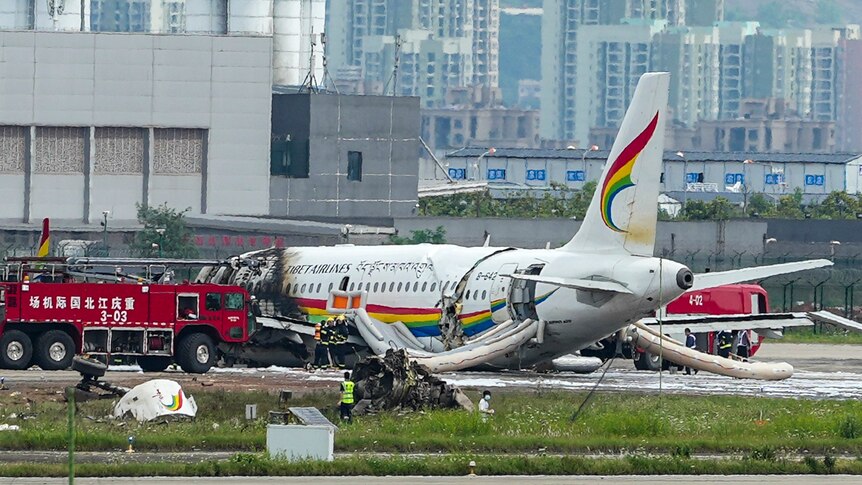 A fire engine and fire crews surround a passenger jet after it veered off a runway and caught fire.