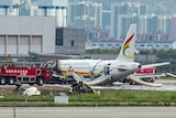A fire engine and fire crews surround a passenger jet after it veered off a runway and caught fire.