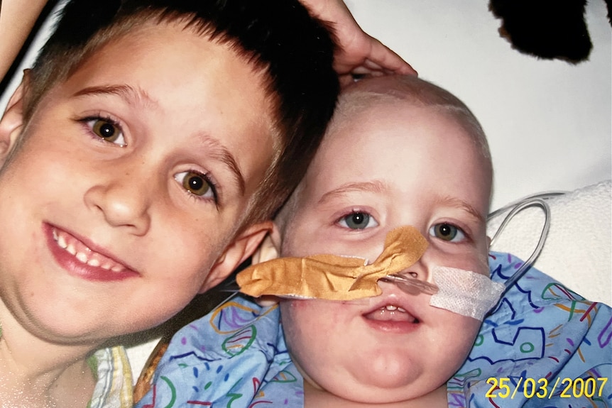 Two young boys in a hospital bed